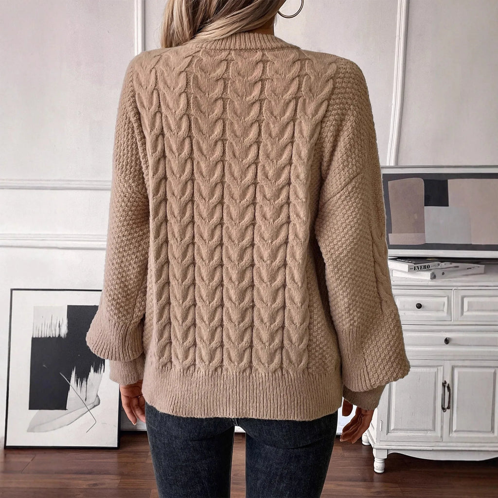 Women's loose beige casual sweater with round neck and twist detail on a hanger.