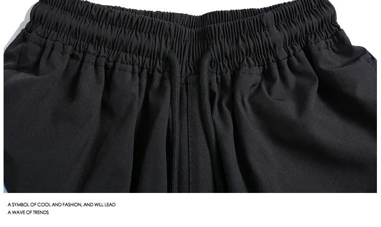 Quick-drying black and grey sports shorts with elastic waistband and straight-leg fit