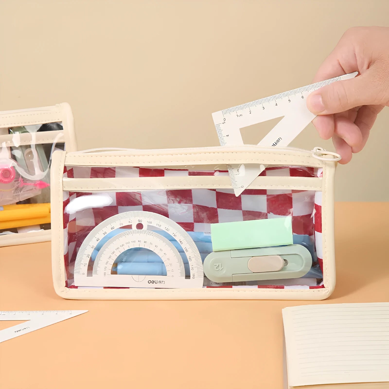 Transparent PVC pencil case with chessboard pattern showing pens inside, black and white grid design