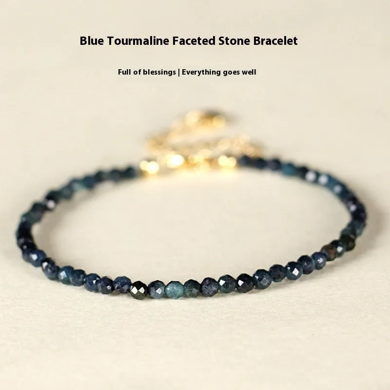 Close-up of a women's blue tourmaline bracelet with 3mm beads and gold spacer beads.