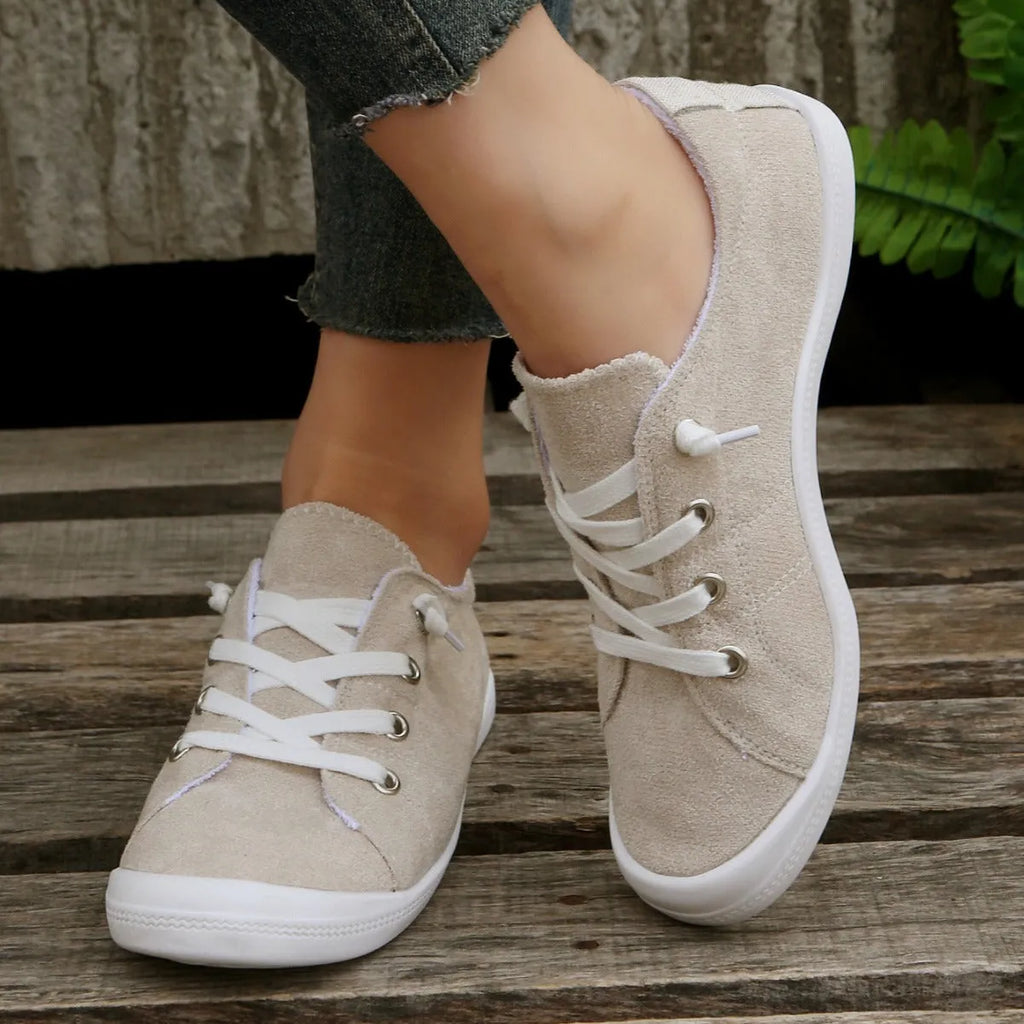 Women's creamy-white fabric casual sneakers with rubber soles shown in low-top design