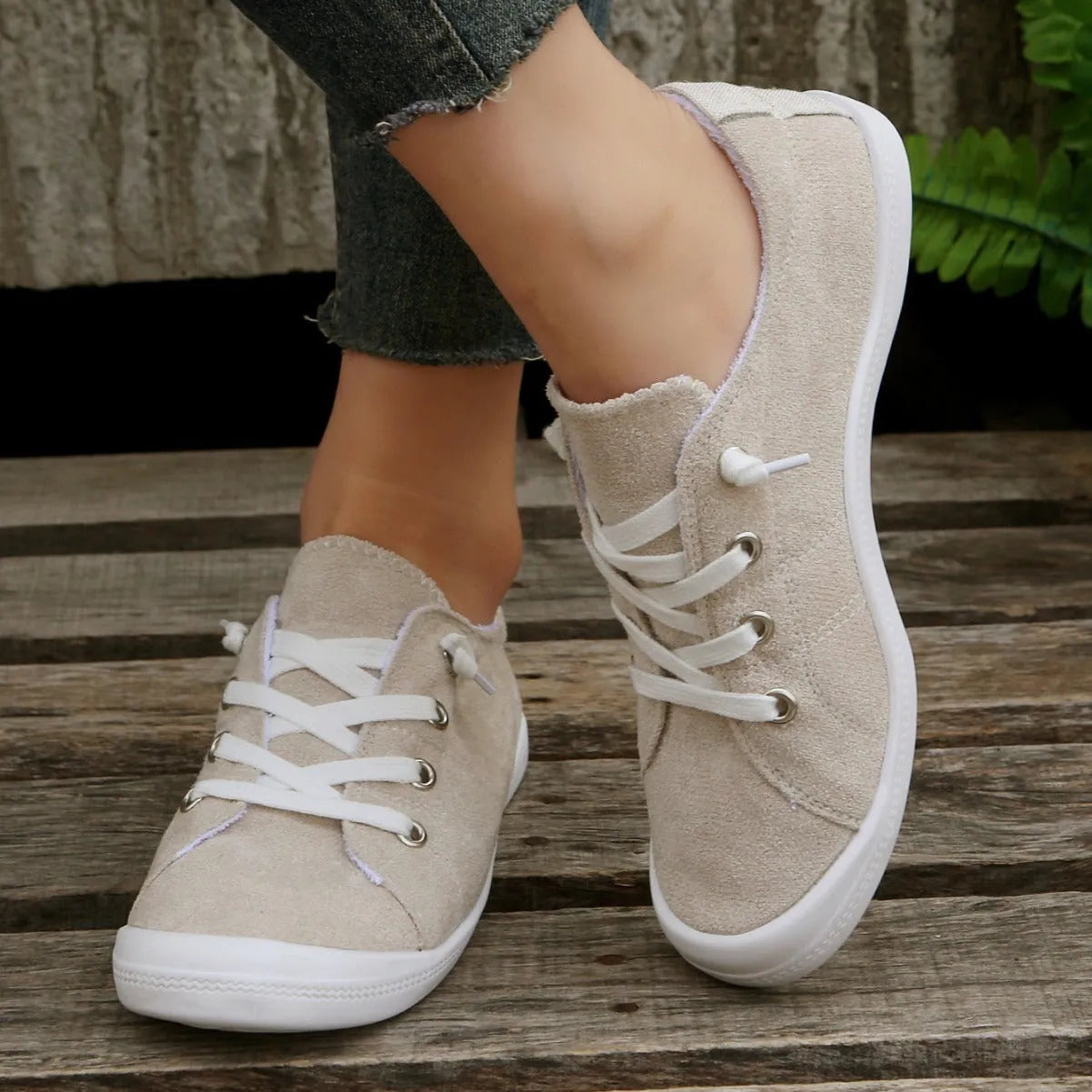 Women's creamy-white fabric casual sneakers with rubber soles shown in low-top design