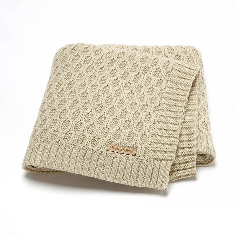 Solid colour infant hug blanket with textured lines, shown in acrylic fabric measuring 70 by 90 cm.