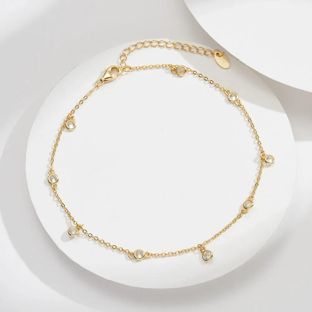 Women's silver anklet with small geometric zirconium pendant in gold tone.