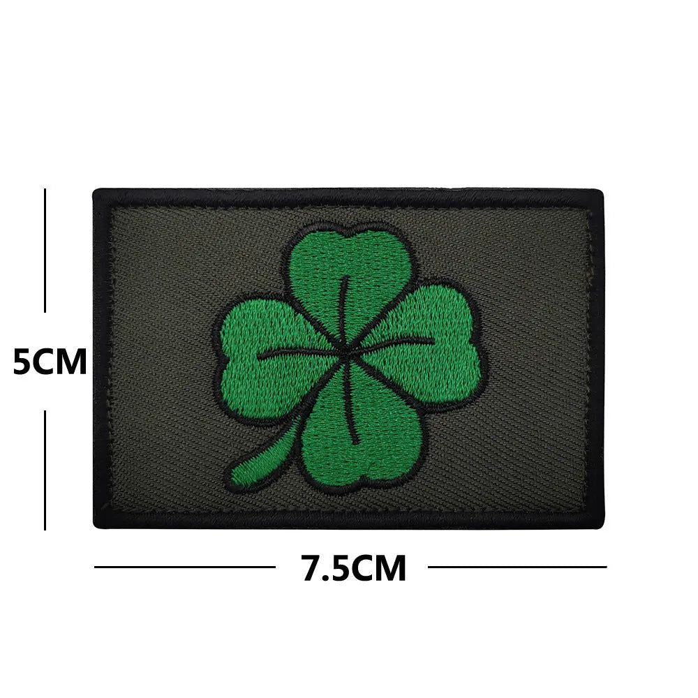Outdoor embroidered fabric badge with Velcro strip backing on a green clover design.