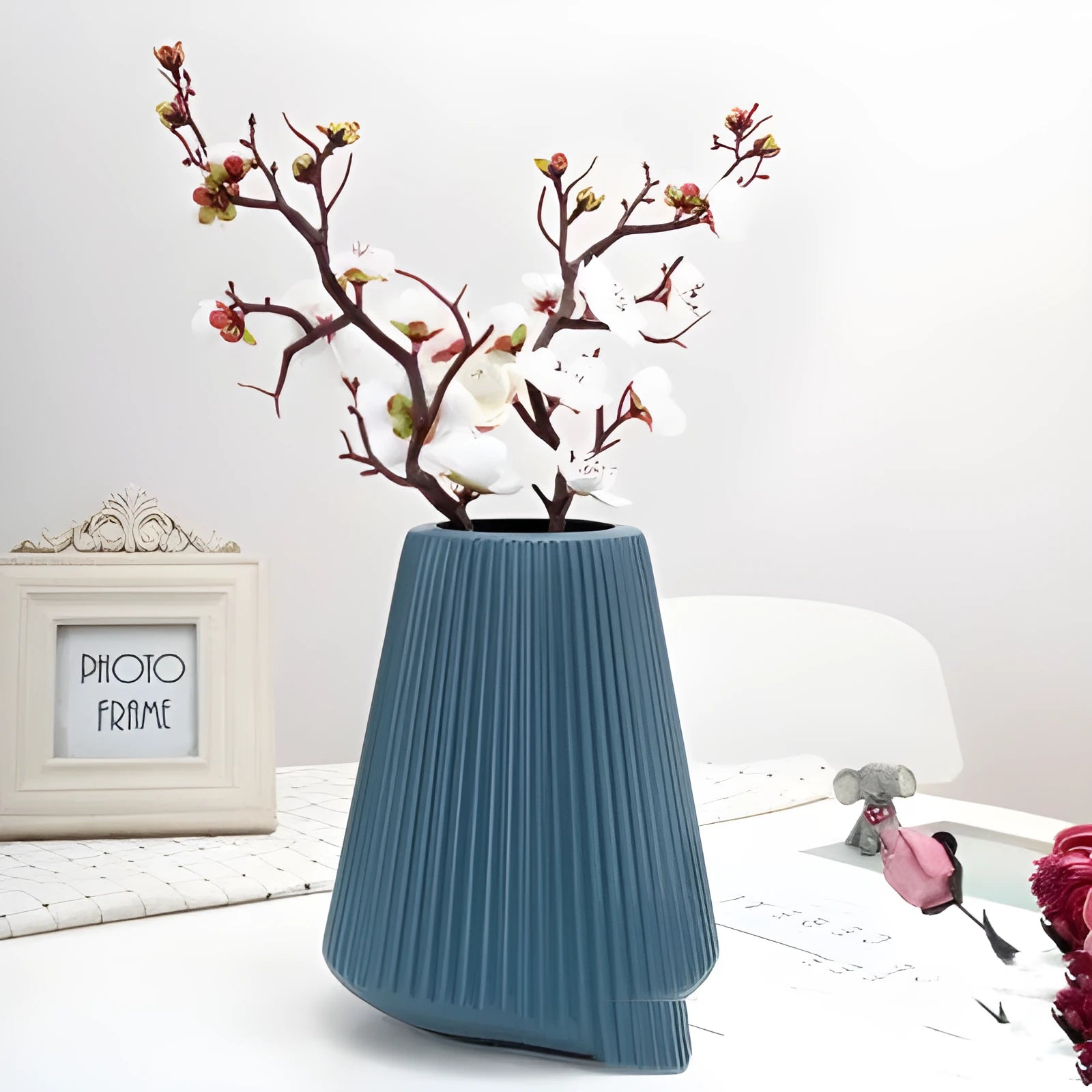 A simple style melamine plastic decorative flower vase in blue, measuring 16cm by 20cm, on a desktop.