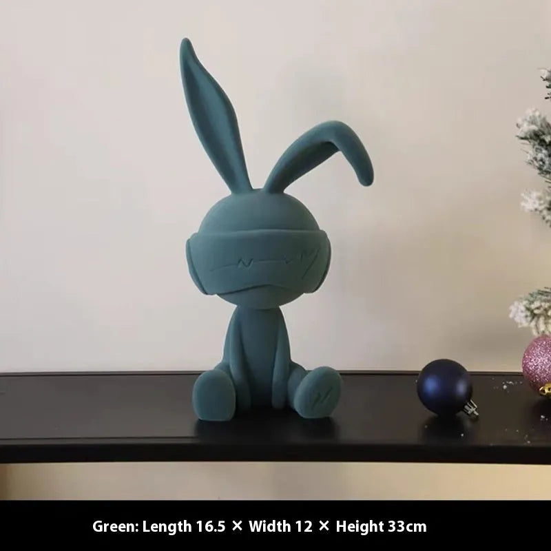 Small resin rabbit table ornament with a suede blindfold, shown in green, blue, and red colour options.