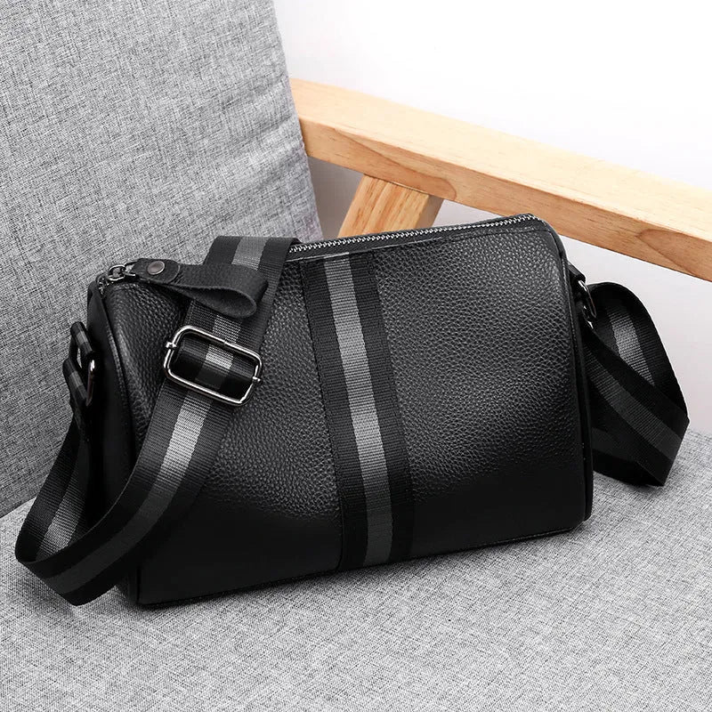 Black genuine leather crossbody bag with adjustable strap and large 24x16x13cm capacity.