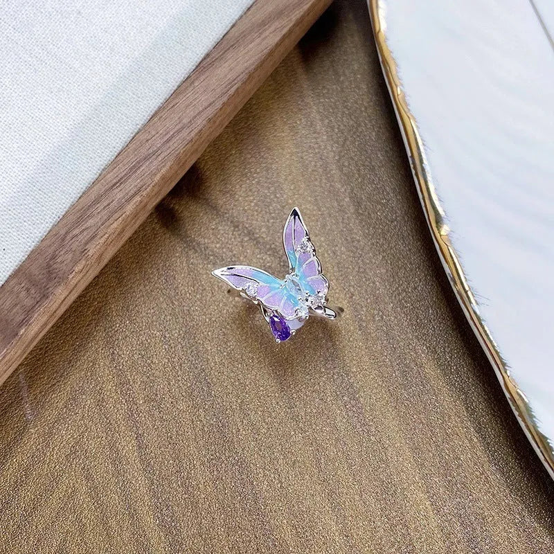 Close-up of an adjustable copper ring with an insect motif and an irregular dripping oil finish.