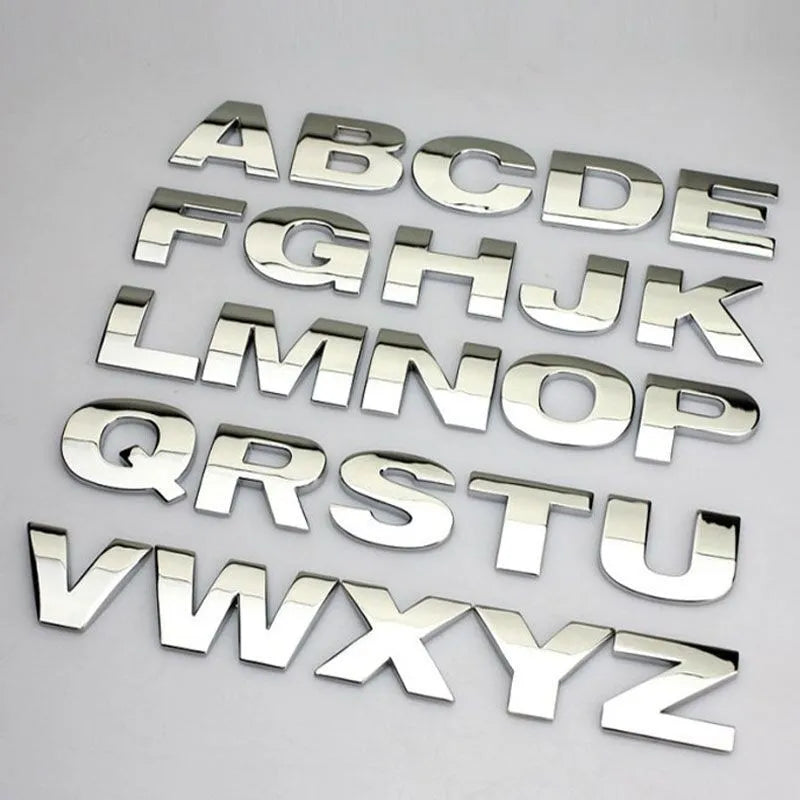 Close-up of a silver zinc alloy 3D raised letter 'A' car bumper sticker, approx 2.5cm tall.
