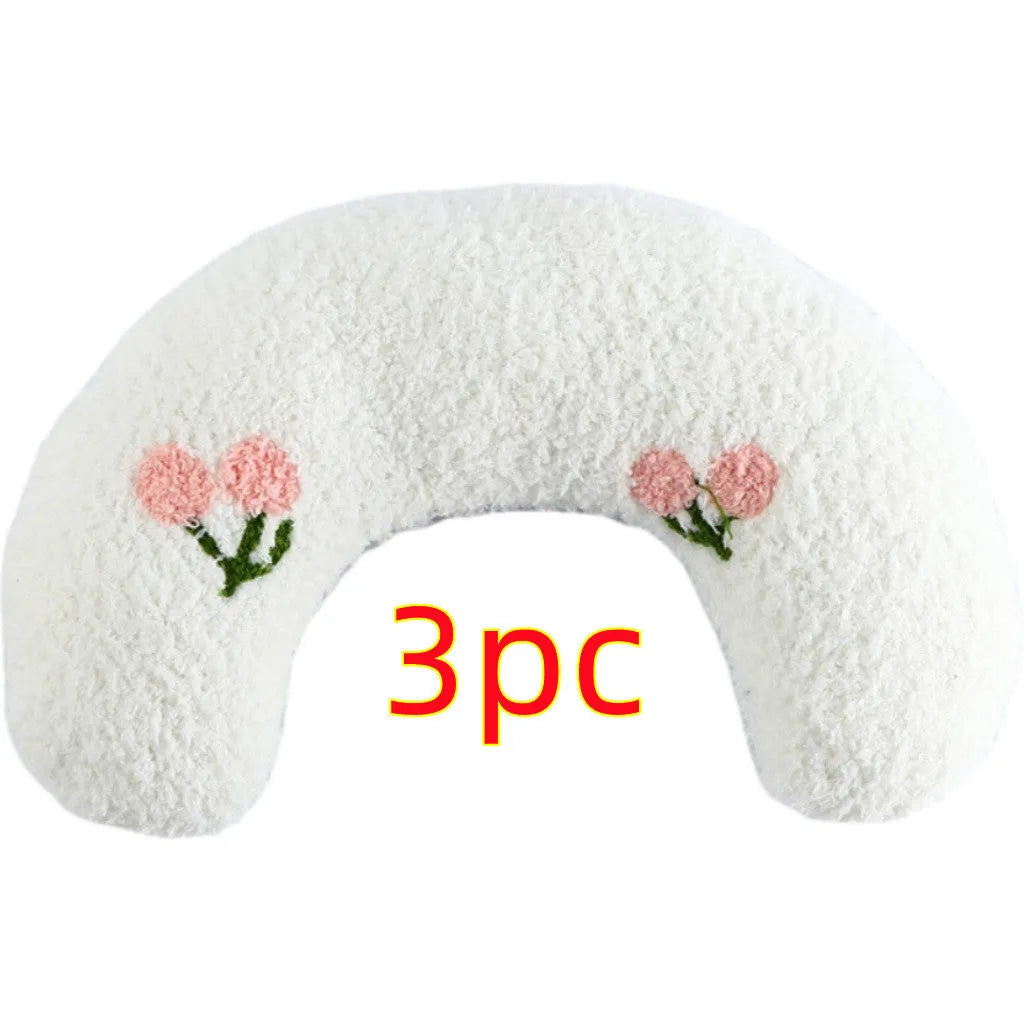 Small white U-shaped plush pet pillow for cats and small dogs on a neutral background.