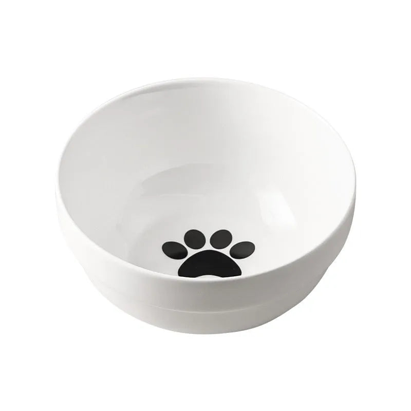 White ceramic cat bowl with decorative pattern sitting in a black iron frame stand.