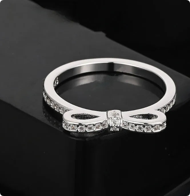 Silver-coloured bow design ring with sparkling rhinestone zircon crystal decoration.