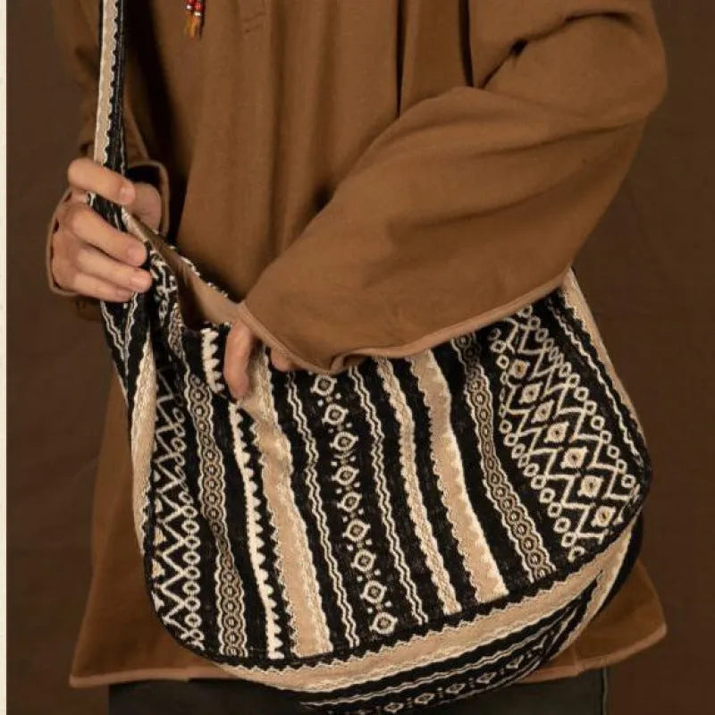 Corduroy vintage messenger bag with jacquard stripes, handprint detail, and an adjustable plaid shoulder strap.