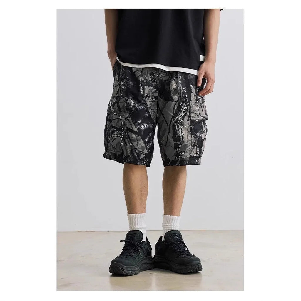 Man's loose straight-leg denim shorts in black on a hanger, showing mid-rise waist and zip fly.