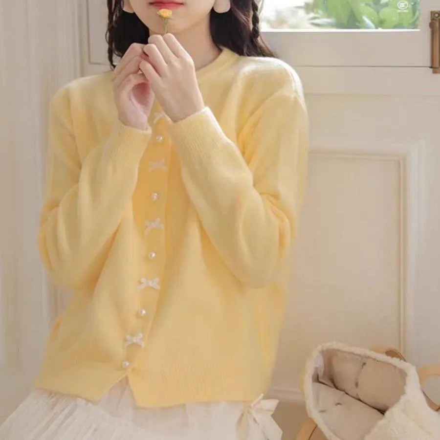 Women's acrylic cashmere cardigan sweater with bow and pearl button detail in nine colour options