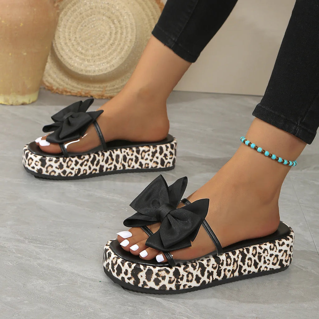 Black leopard print scaffold-shaped beach slippers with thick sole and round toe on white background