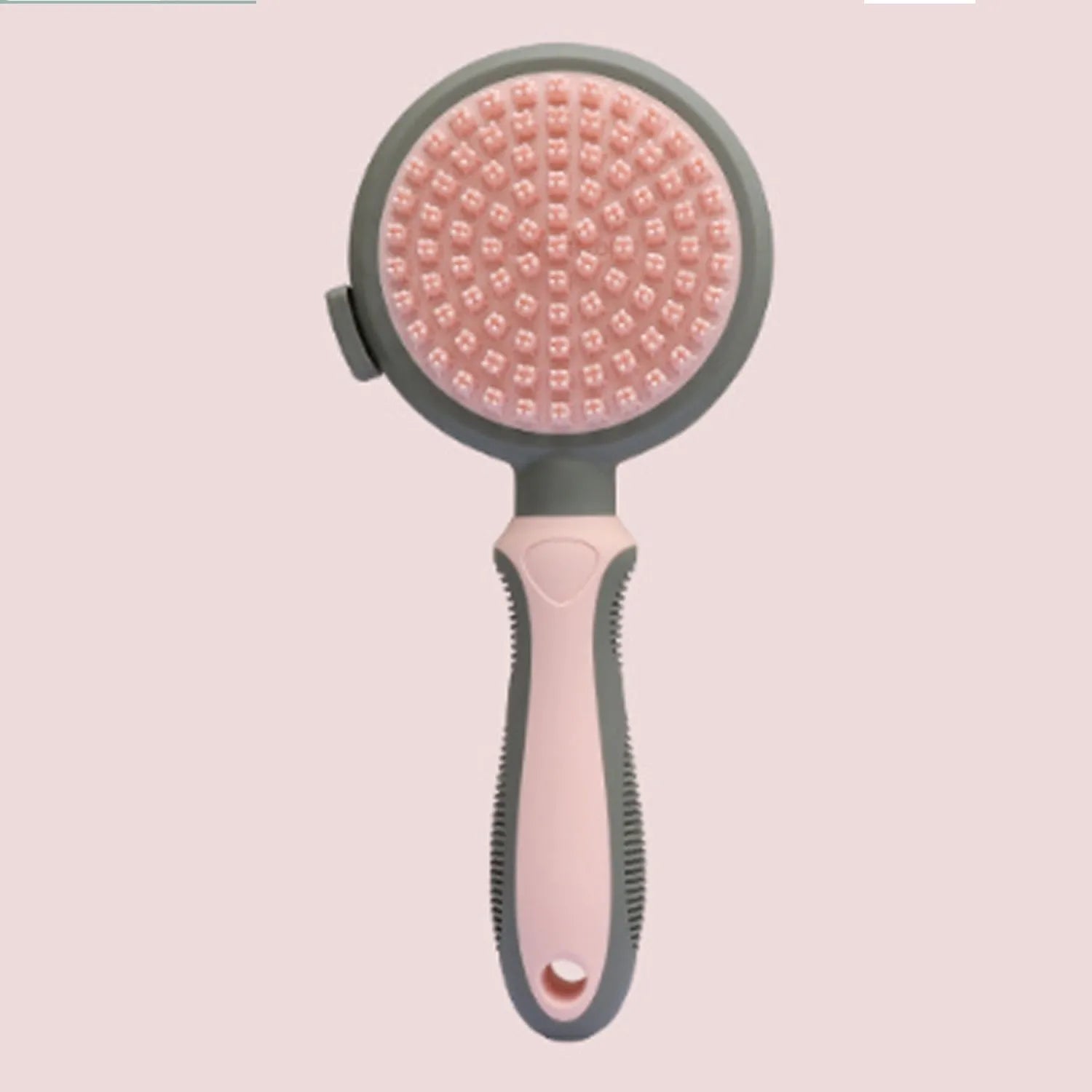 Pink double-sided cat grooming brush with release button next to a flea comb on a white background.