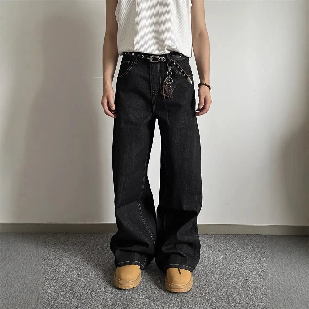 A pair of black loose wide-leg jeans with a straight-leg cut and zip fly on a mannequin.