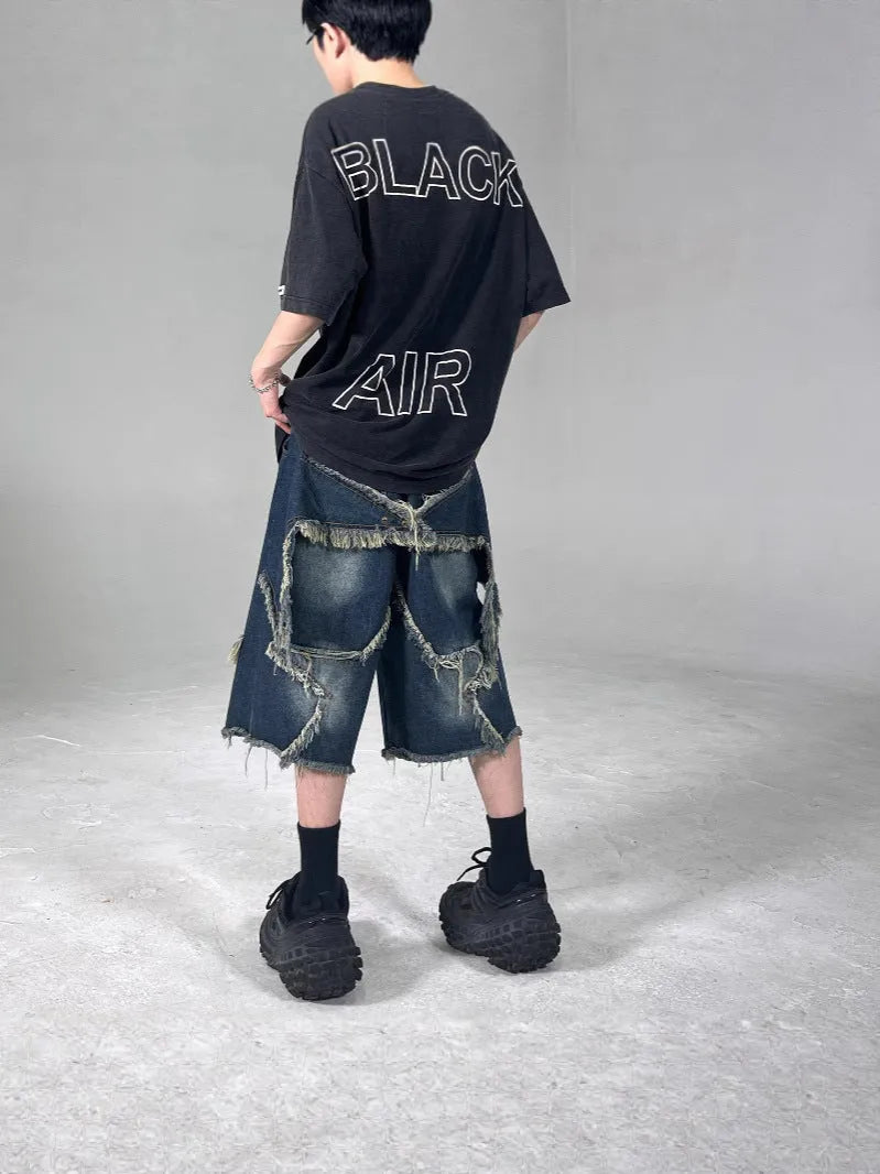 Blue men's denim shorts with a frayed hem and a large five-pointed star design on the leg.