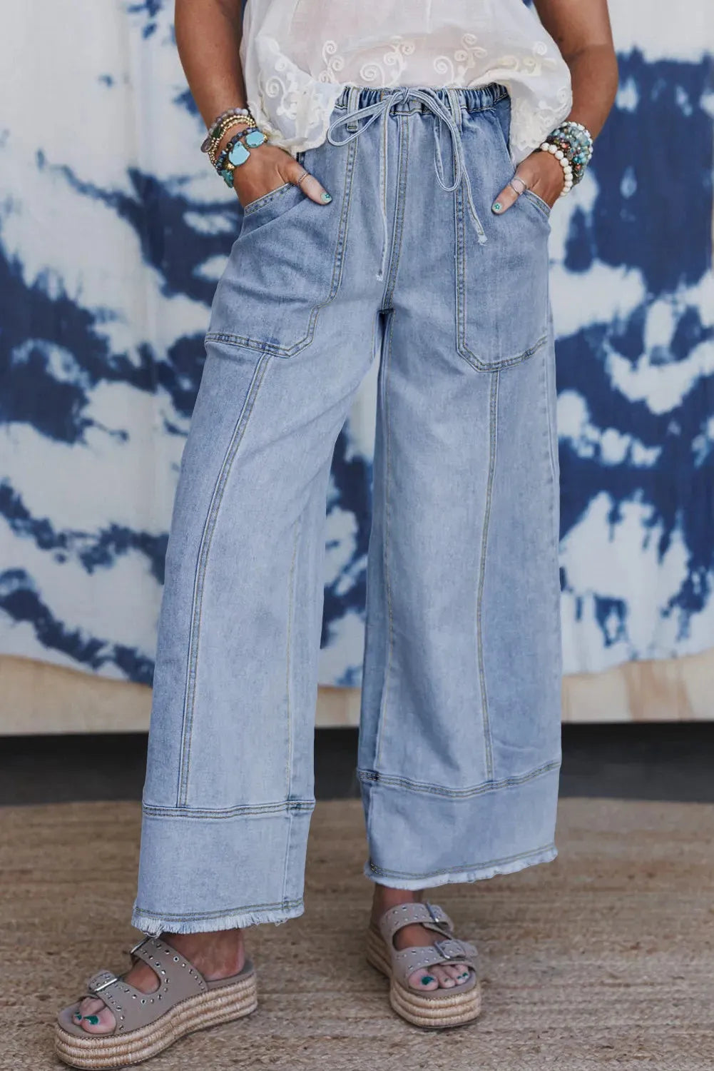 Beau blue women's wide leg denim trousers with drawstring waist and raw hem detail.
