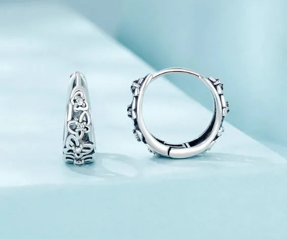 Sterling silver hollow butterfly earrings with zircon accents on white background