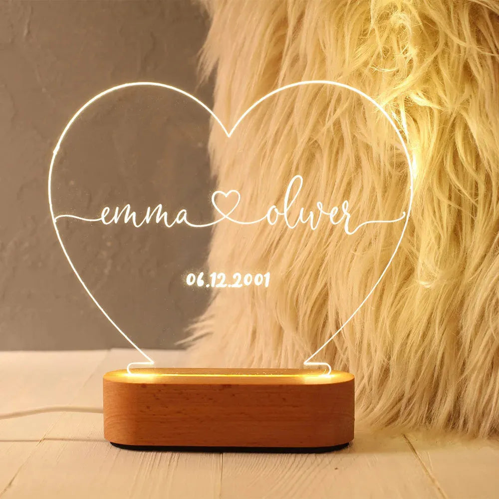 Custom transparent acrylic night light with engraved names and date, lit by LED base.