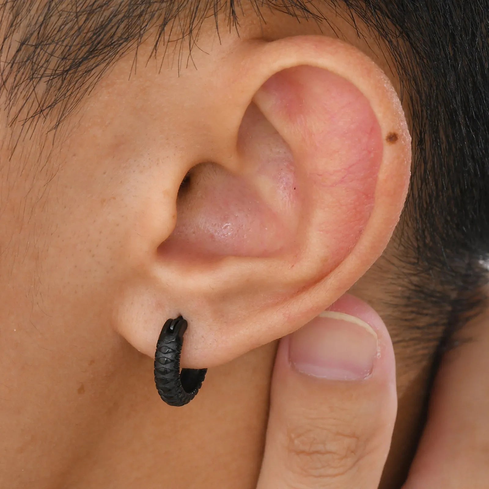 A pair of stainless steel hip hop earrings with a raised snake pattern, shown in black and gold colour options.