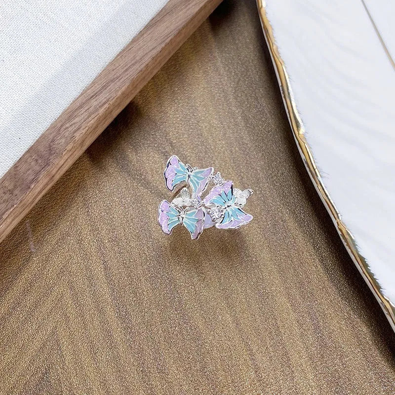 Close-up of an adjustable copper ring with an insect motif and an irregular dripping oil finish.