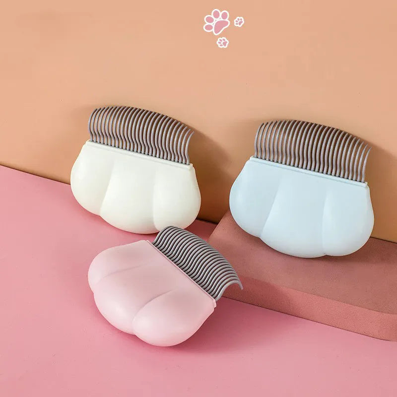 Paw Soft Deshedding Brush grooming tool for cats and dogs in blue, pink, or white on a white background.