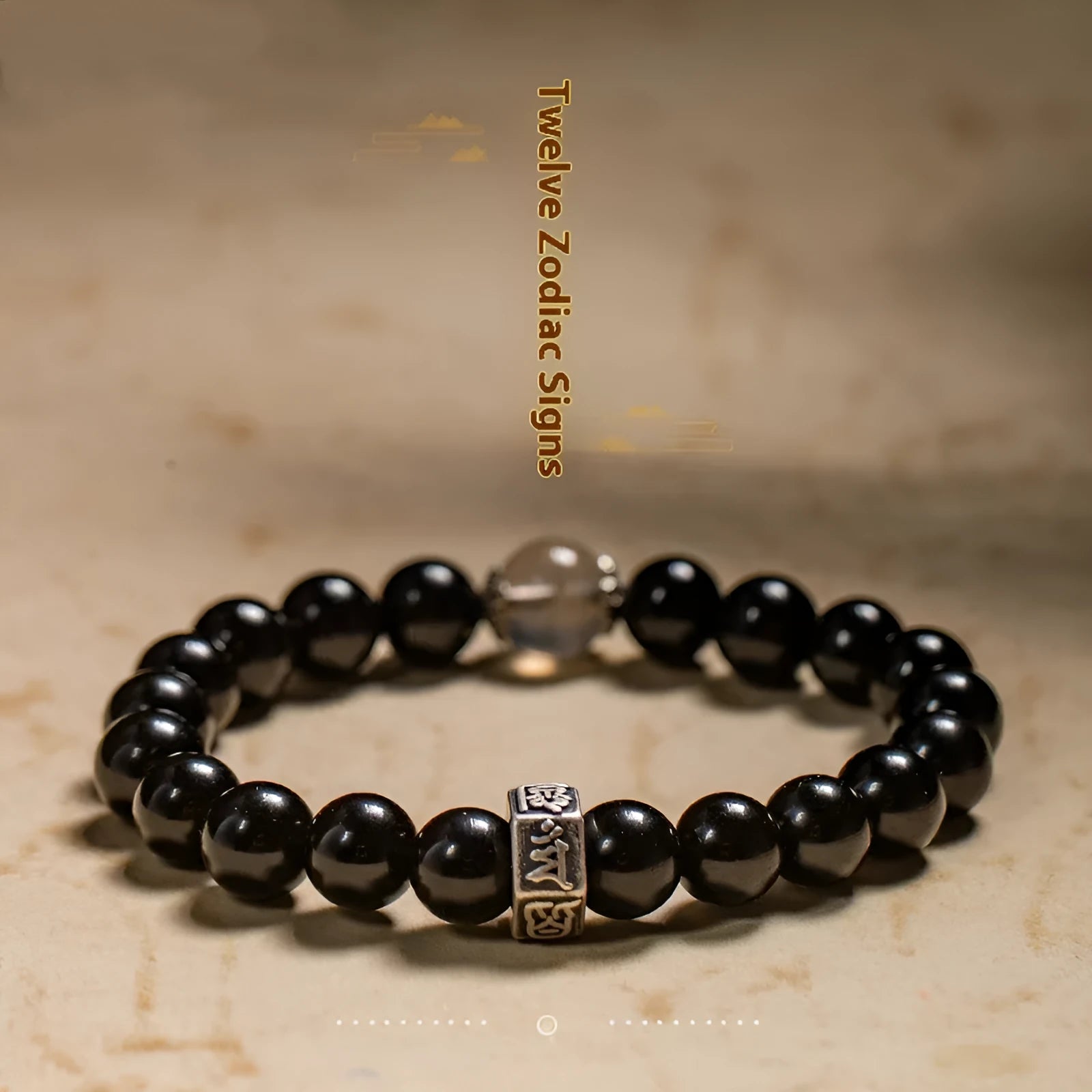 Dark 8mm obsidian bracelet with carved Chinese zodiac animal design on a wrist.