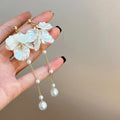 Long shell pearl tassel earrings with acrylic construction and multiple ear clip options