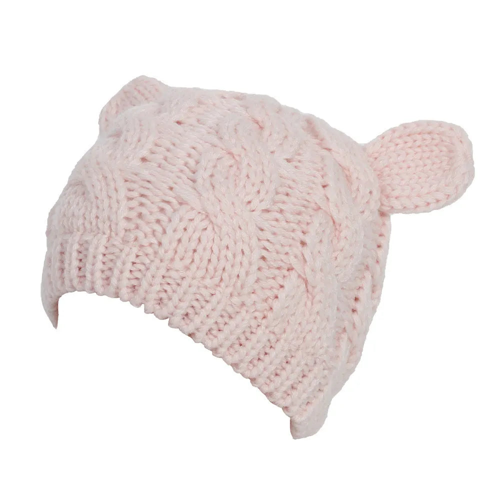 Handmade red knitted beanie with 3D cat ears on a white background.