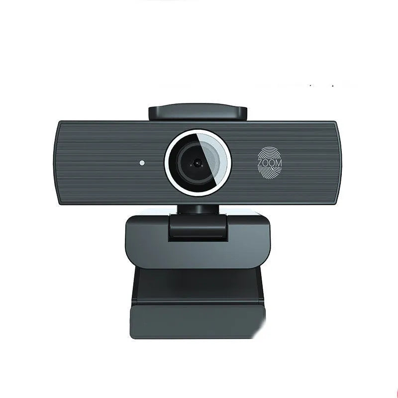 Black USB webcam with attached cable and a magnetic privacy cover on a desk.