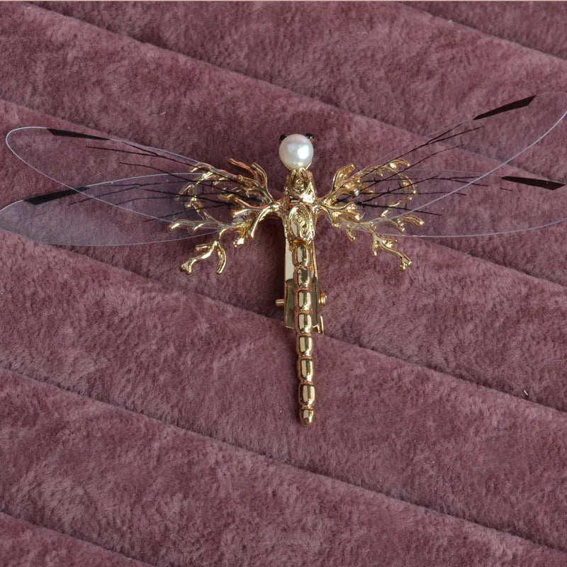 Golden alloy dragonfly-shaped side clip headdress for women on a white background.