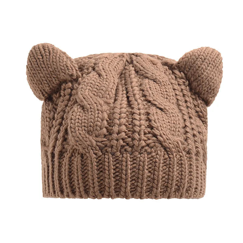 Handmade red knitted beanie with 3D cat ears on a white background.