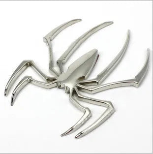 Three-dimensional metal spider bumper sticker in zinc alloy, shown in gold colour.