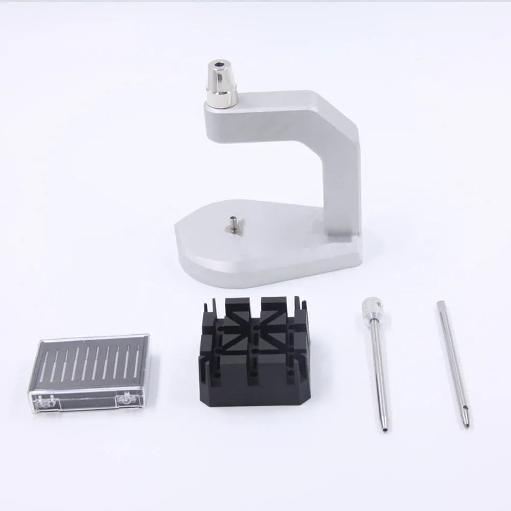 Silver coloured tool steel press strap removal tool for watch and jewellery repair on a dark surface.