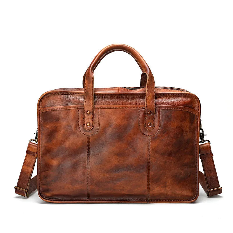 Vintage brown leather men's briefcase open showing internal laptop pocket and document organisers