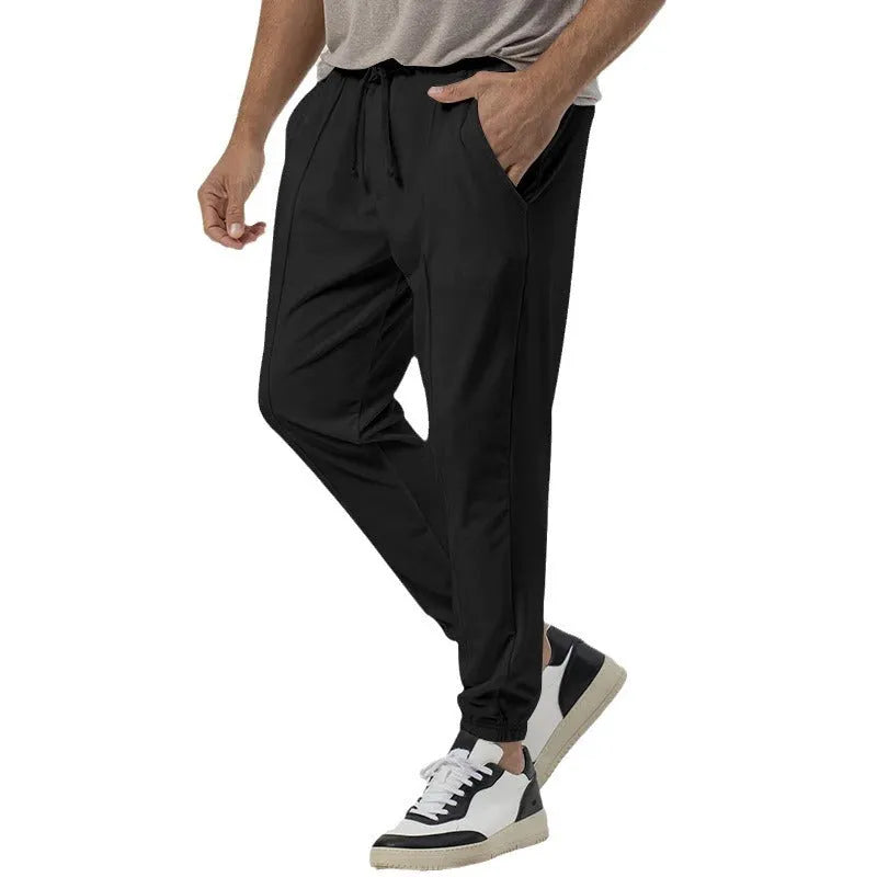 Men's loose tapered casual sweatpants in a grey cotton blend fabric with an elastic waistband.
