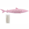 Green silicone fish-shaped cat chew toy with breathable side holes on wooden floor
