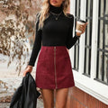 Women's black high waist short skirt with stitched detail and front zipper on a model.