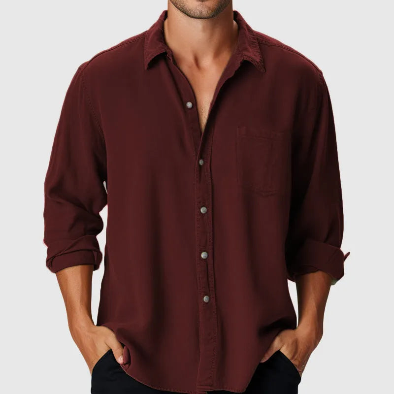 Man wearing a loose-fit long sleeve casual shirt with a stand collar, suitable for beach holidays.