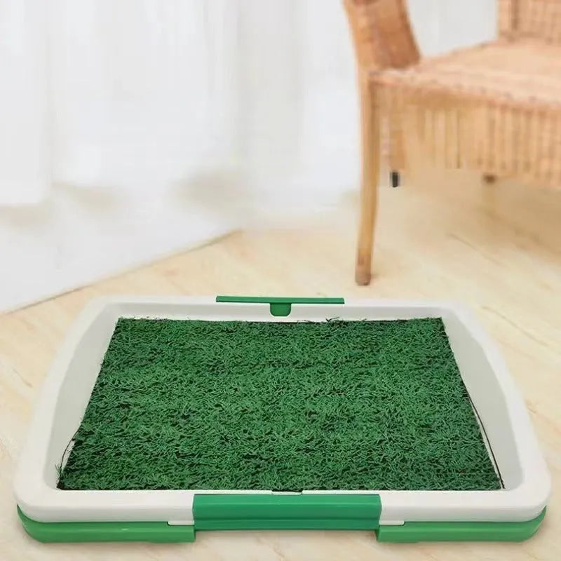 Green synthetic turf dog toilet trainer with three-layer plastic tray system for indoor use.