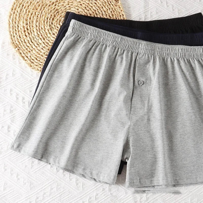 Men's high-waisted loose-fit cotton boxer shorts in black, grey, and navy blue.