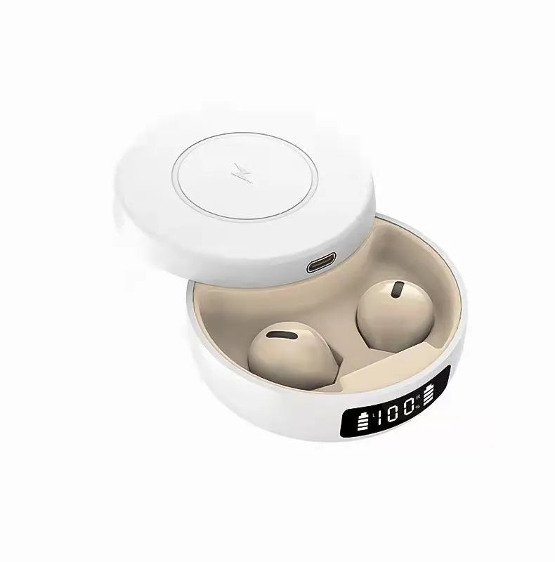 Mini black and white semi-in-ear wireless headphones with their charging case on a table.
