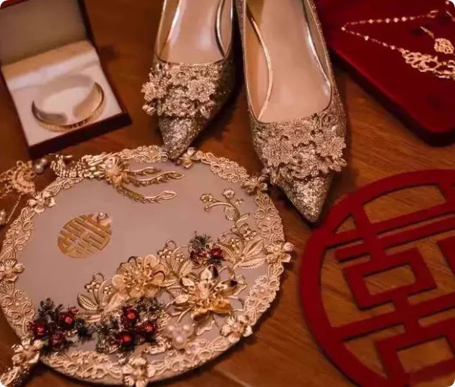 Champagne pointed-toe women's bridal shoes with floral rhinestone detail on a white background