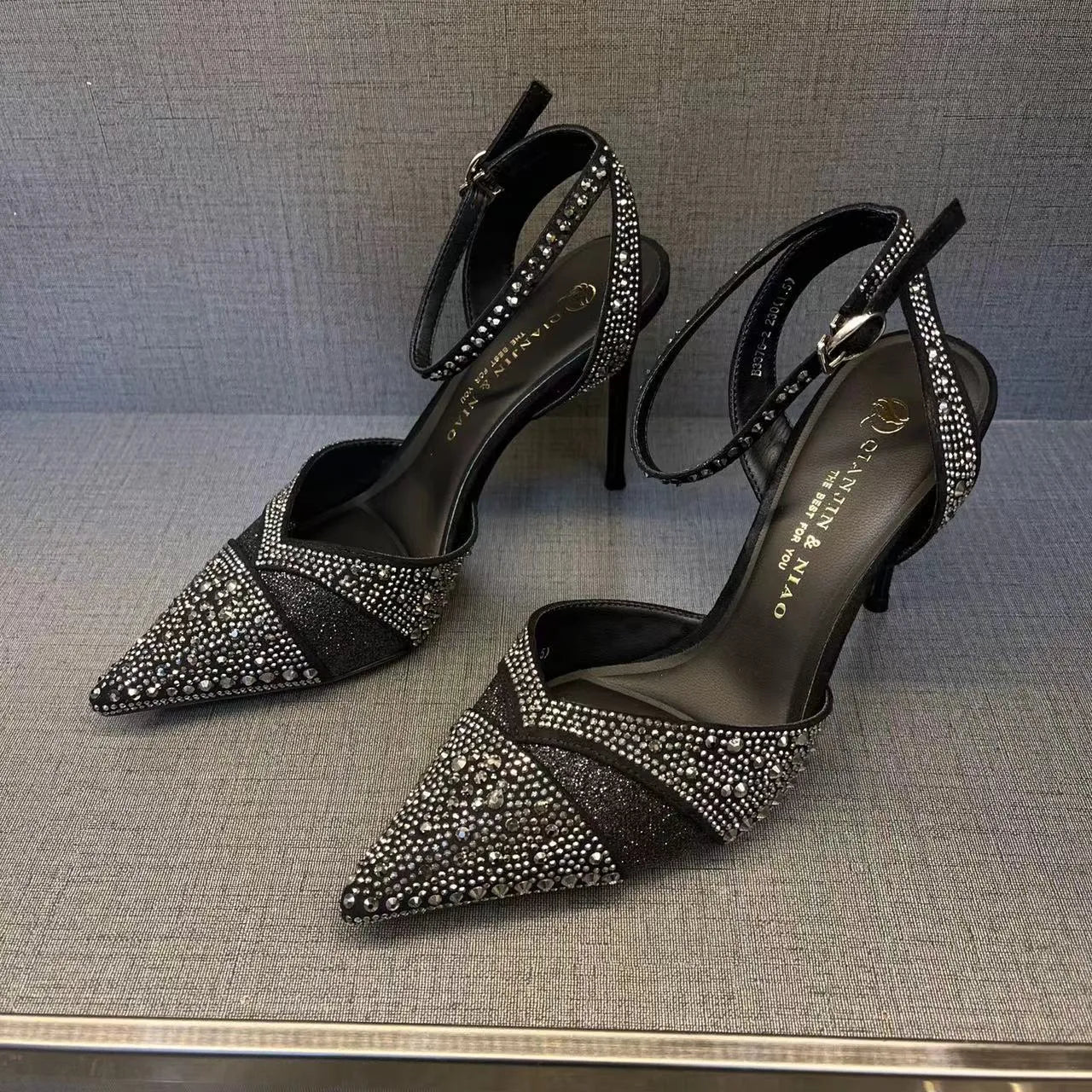 Women's black hollow high heels with red sole and pointed toe on a stiletto heel