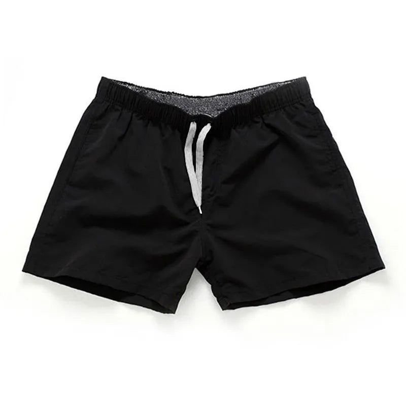 Men's straight-leg beach shorts in polyester fabric shown in a solid colour, laid flat.