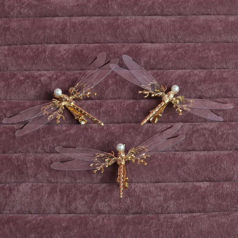 Golden alloy dragonfly-shaped side clip headdress for women on a white background.